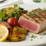 A plated tuna steak with fresh sides